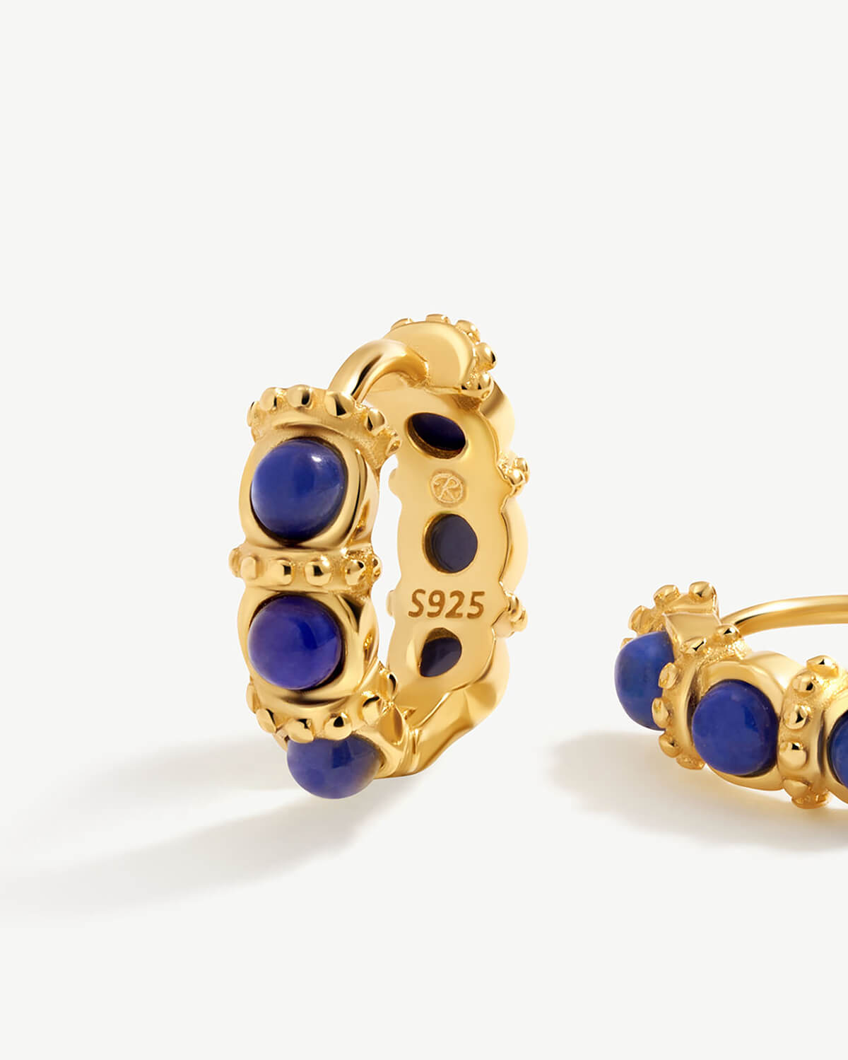 a pair of gold and lapis hoop earrings