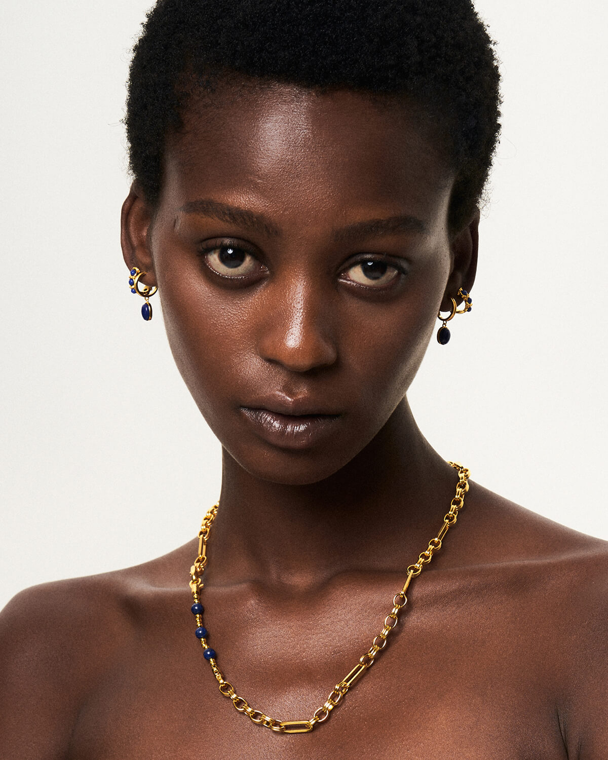 a woman with a necklace and earrings on her neck