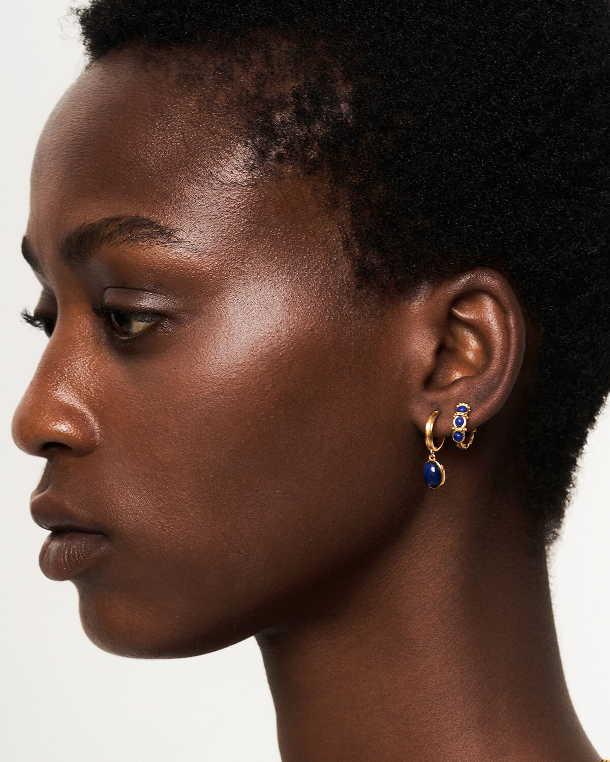 a close up of a person wearing a pair of earrings