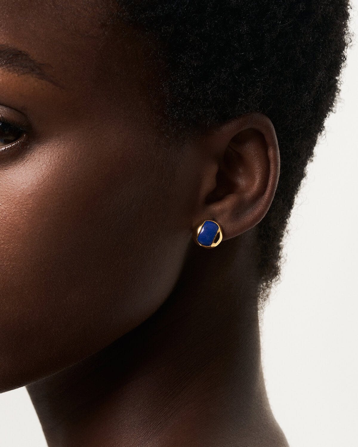 a close up of a person wearing a pair of earrings