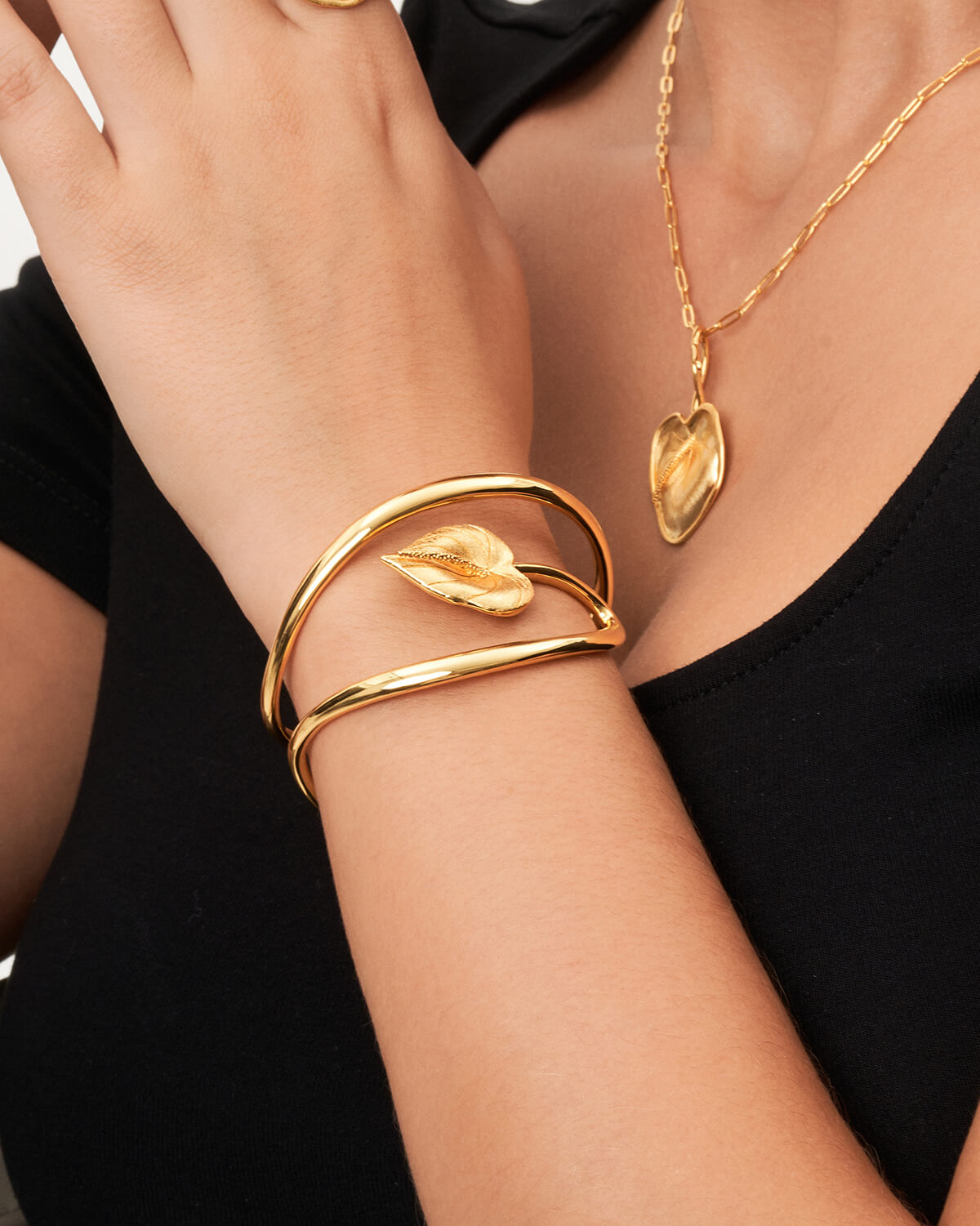 a woman wearing a black shirt and a gold bracelet