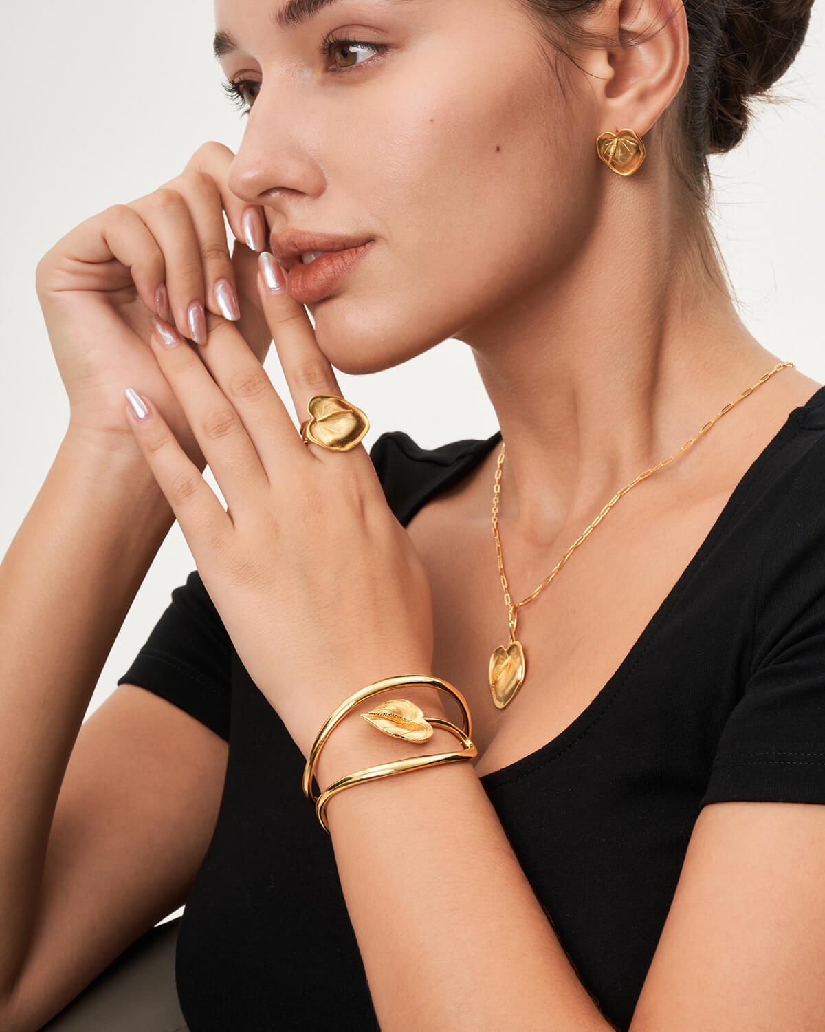 a woman wearing a black shirt and gold jewelry