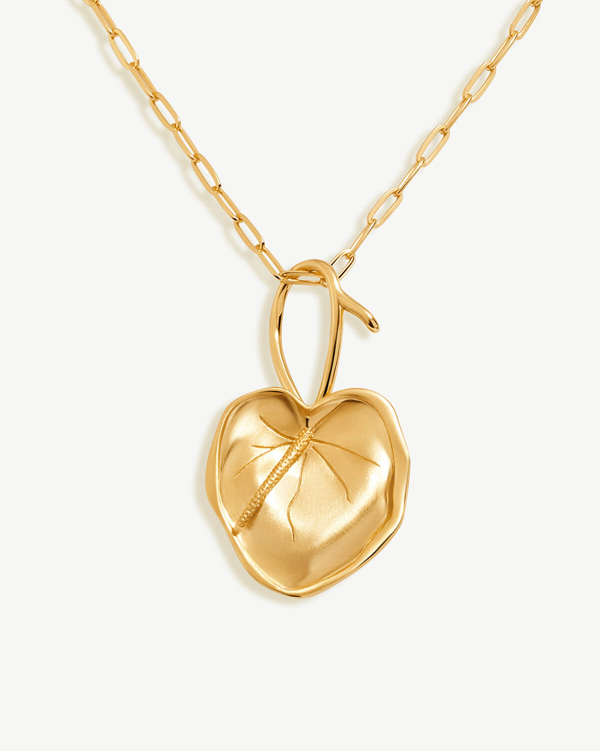 a gold heart pendant on a chain