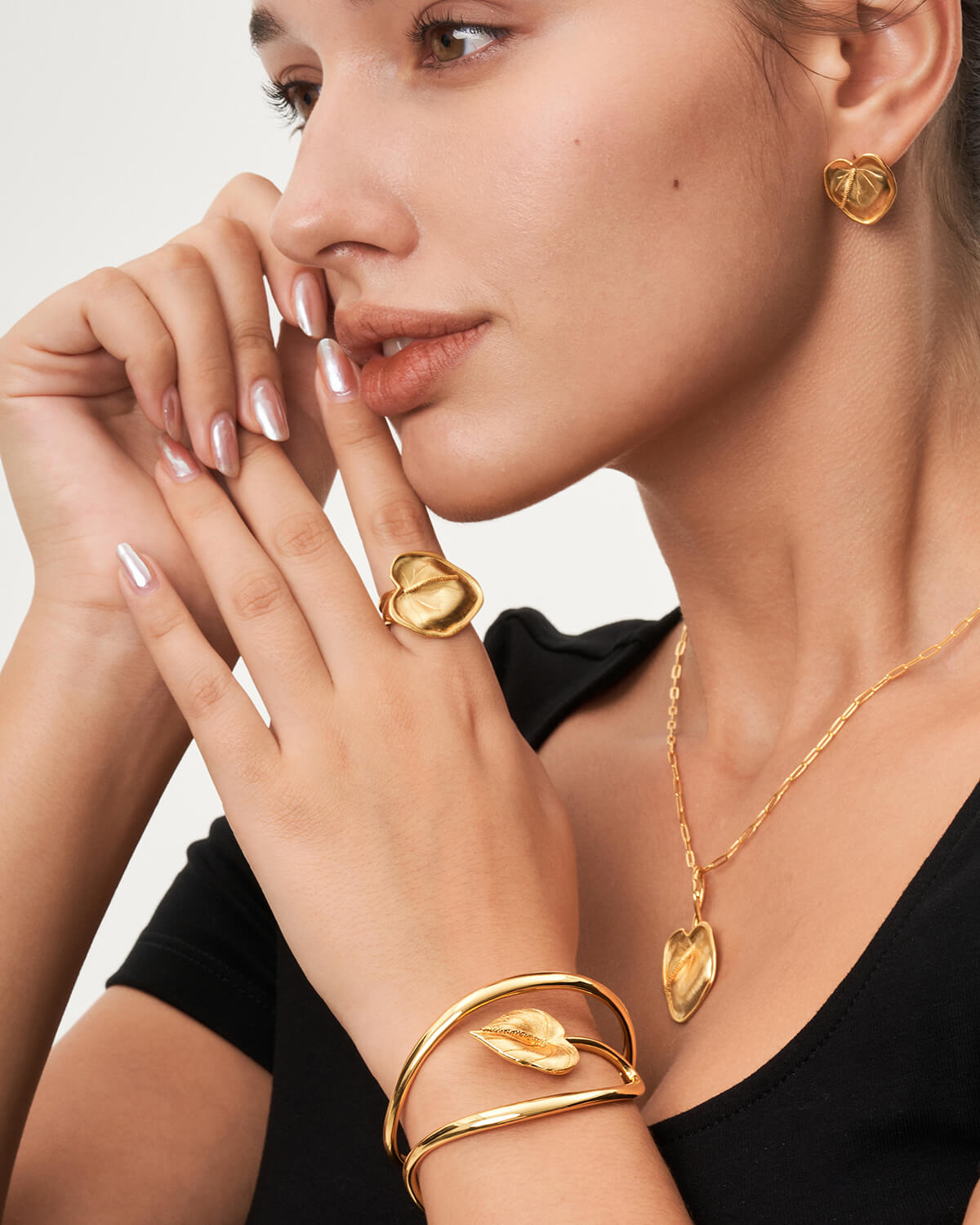 a woman wearing a black top and gold jewelry