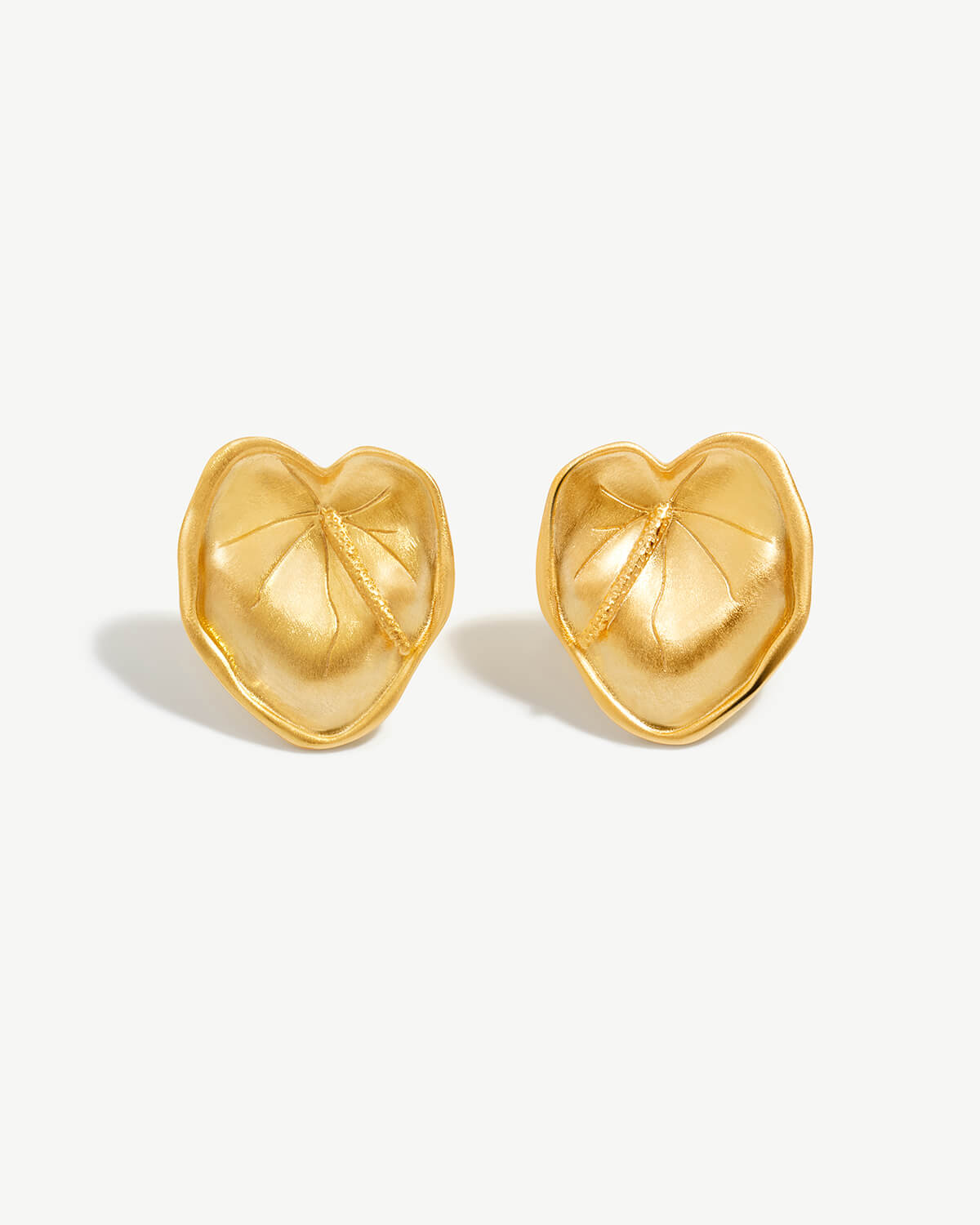 a pair of gold heart shaped earrings