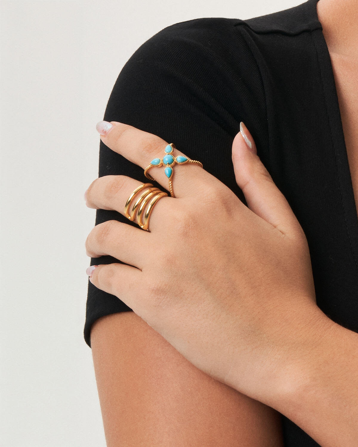 a woman wearing a ring with a turquoise star on it