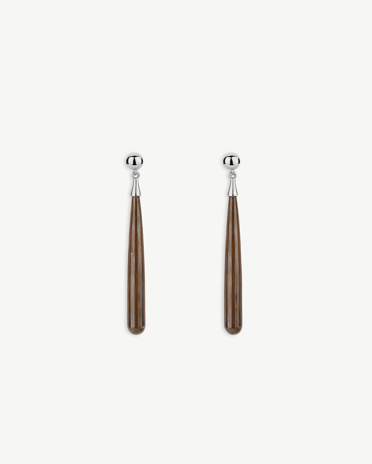 a pair of silver and wood earrings on a white background