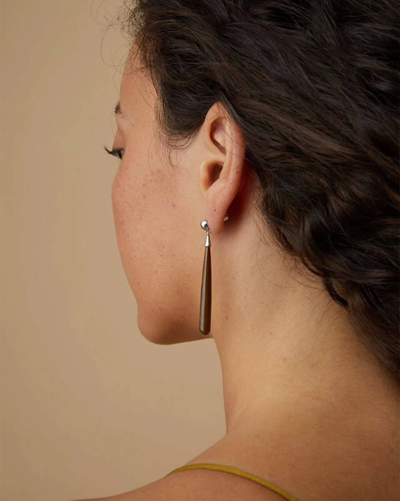 a close up of a person wearing a pair of earrings