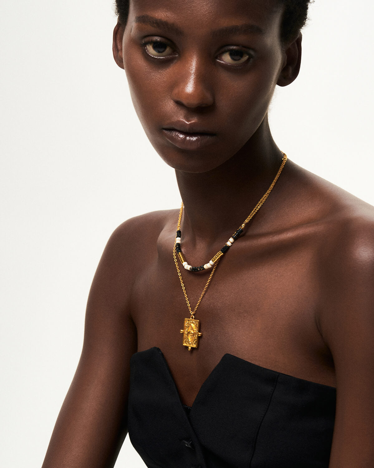 a woman wearing a necklace with a cross on it