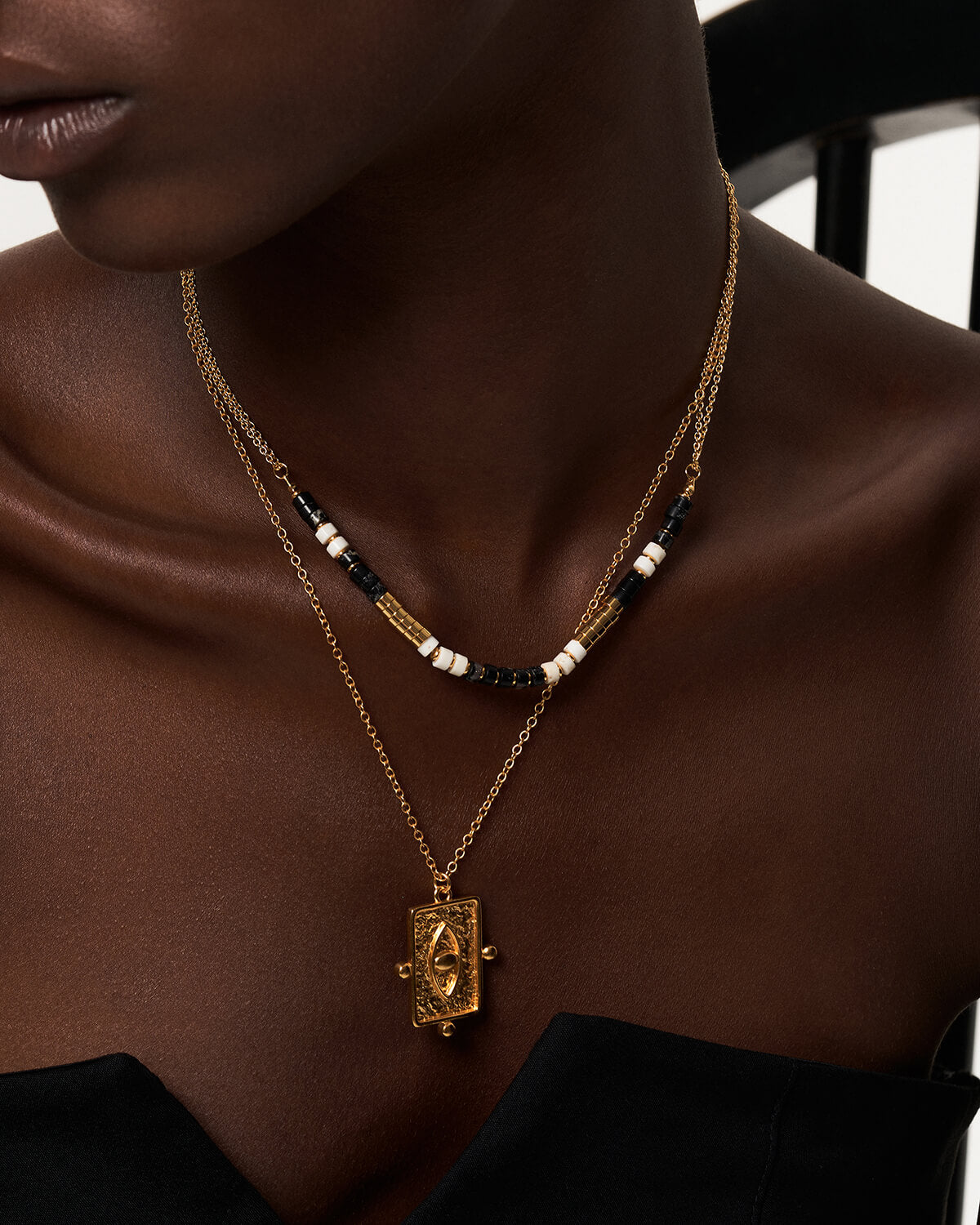 a woman wearing a necklace with a cross on it