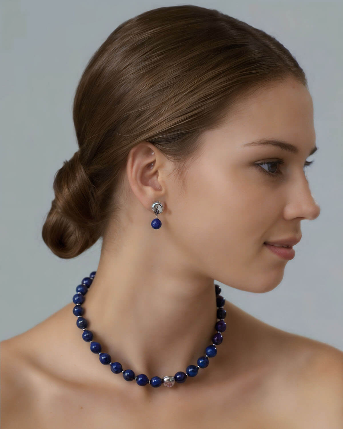 a woman wearing a blue necklace and earrings