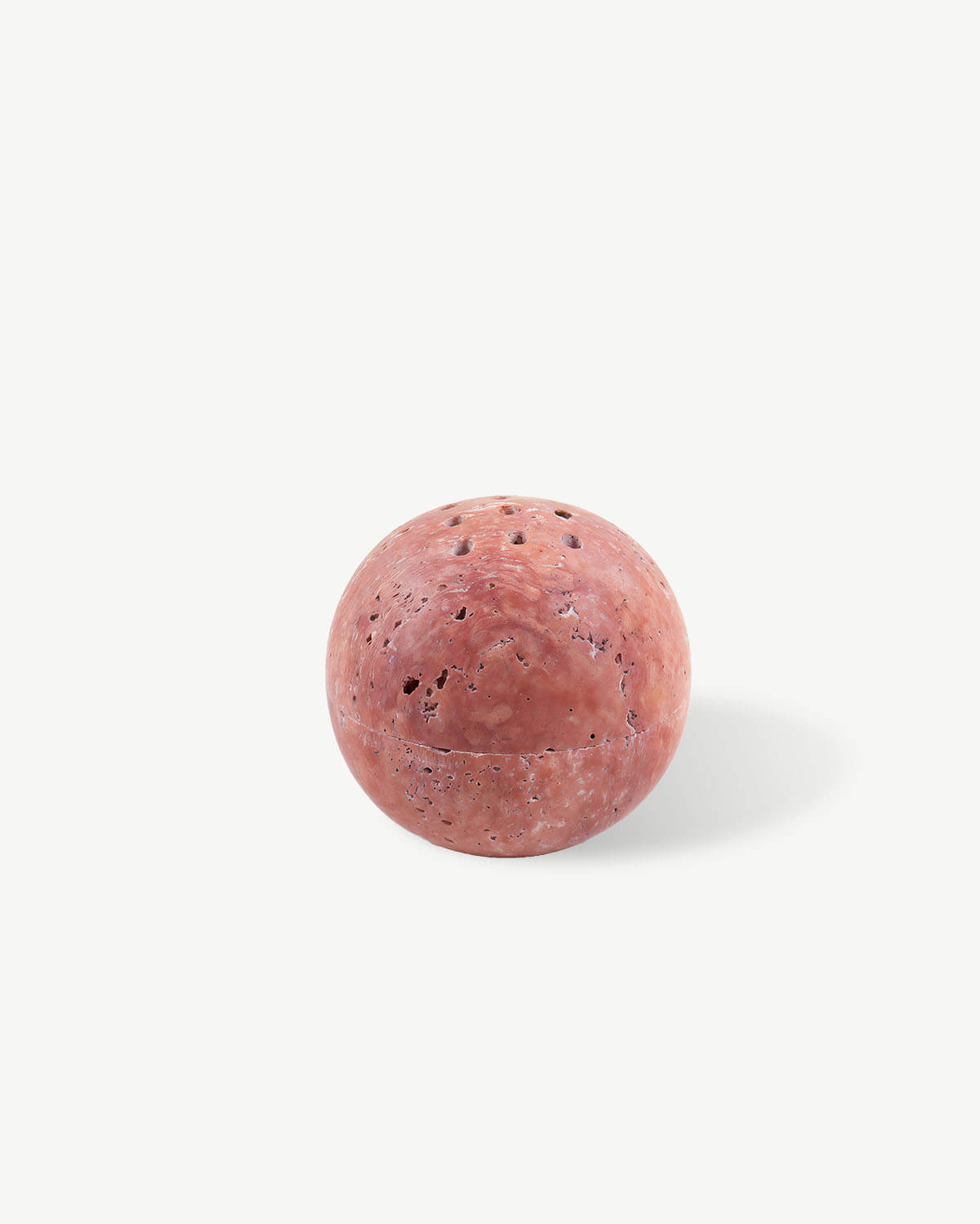 a pink ball of soap on a white background