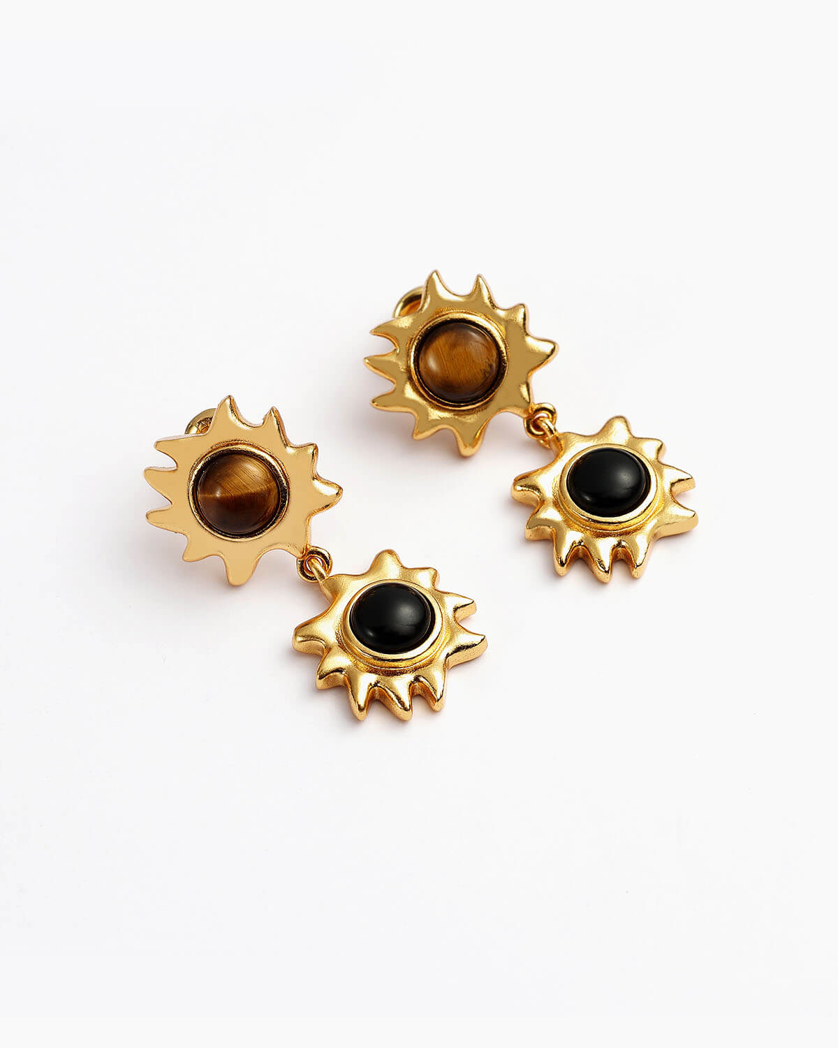 a pair of gold earrings with black stones