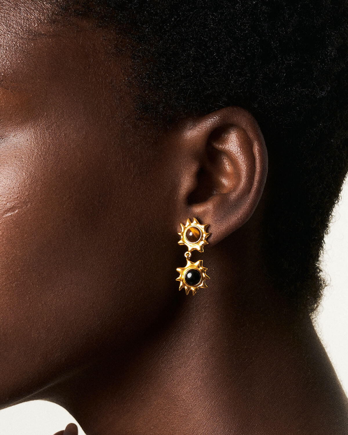 a close up of a person wearing a pair of earrings