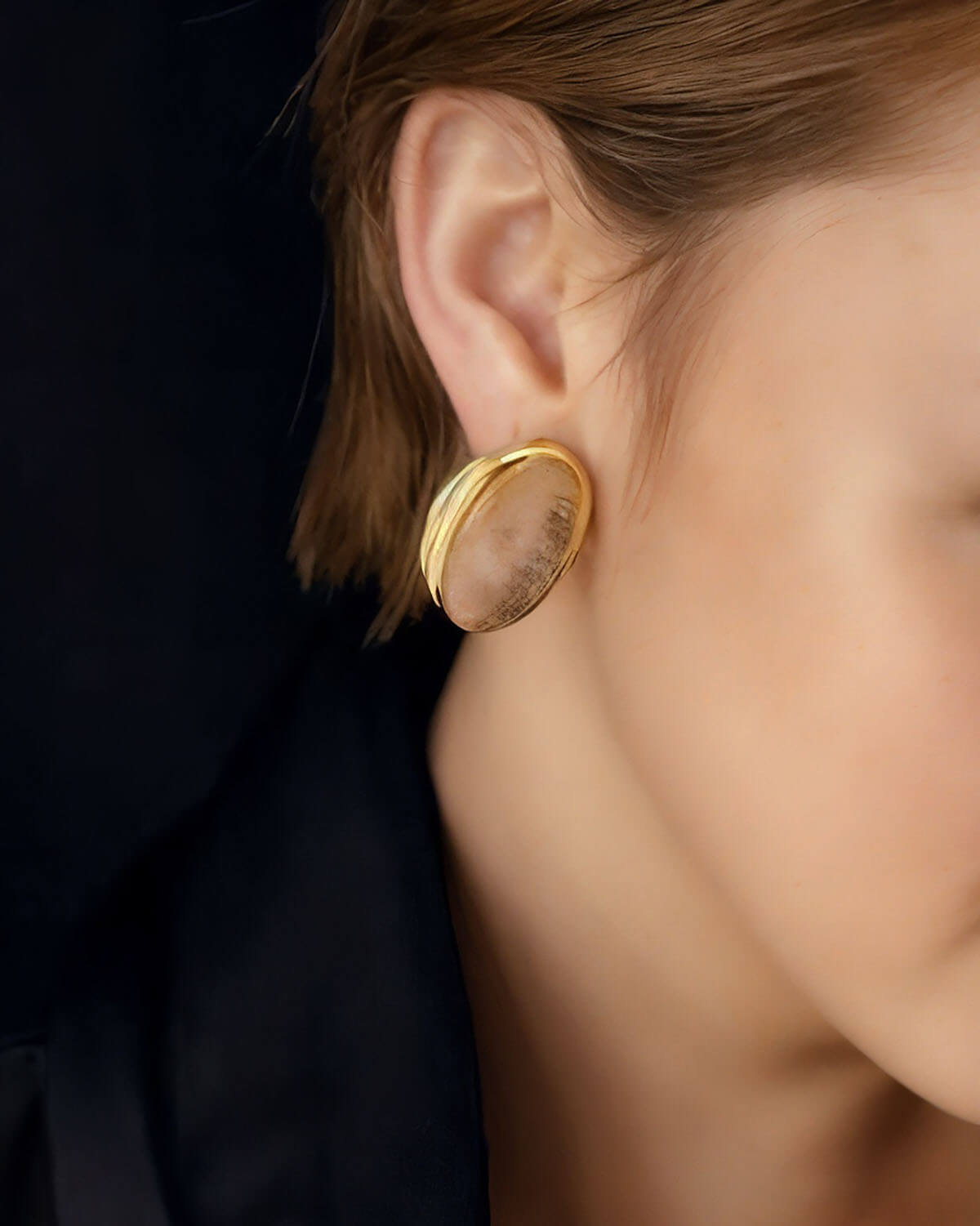 a close up of a person wearing a pair of earrings