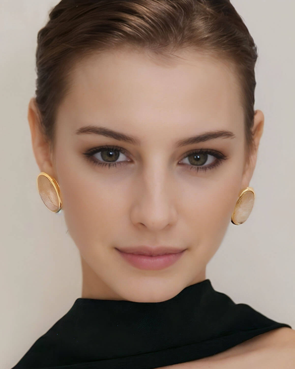 a woman with a black dress and gold earrings