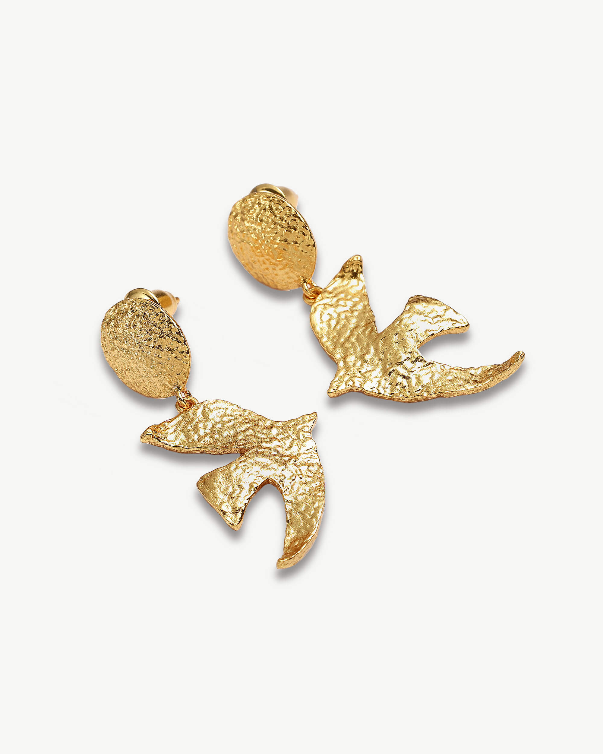 a pair of gold earrings on a white background