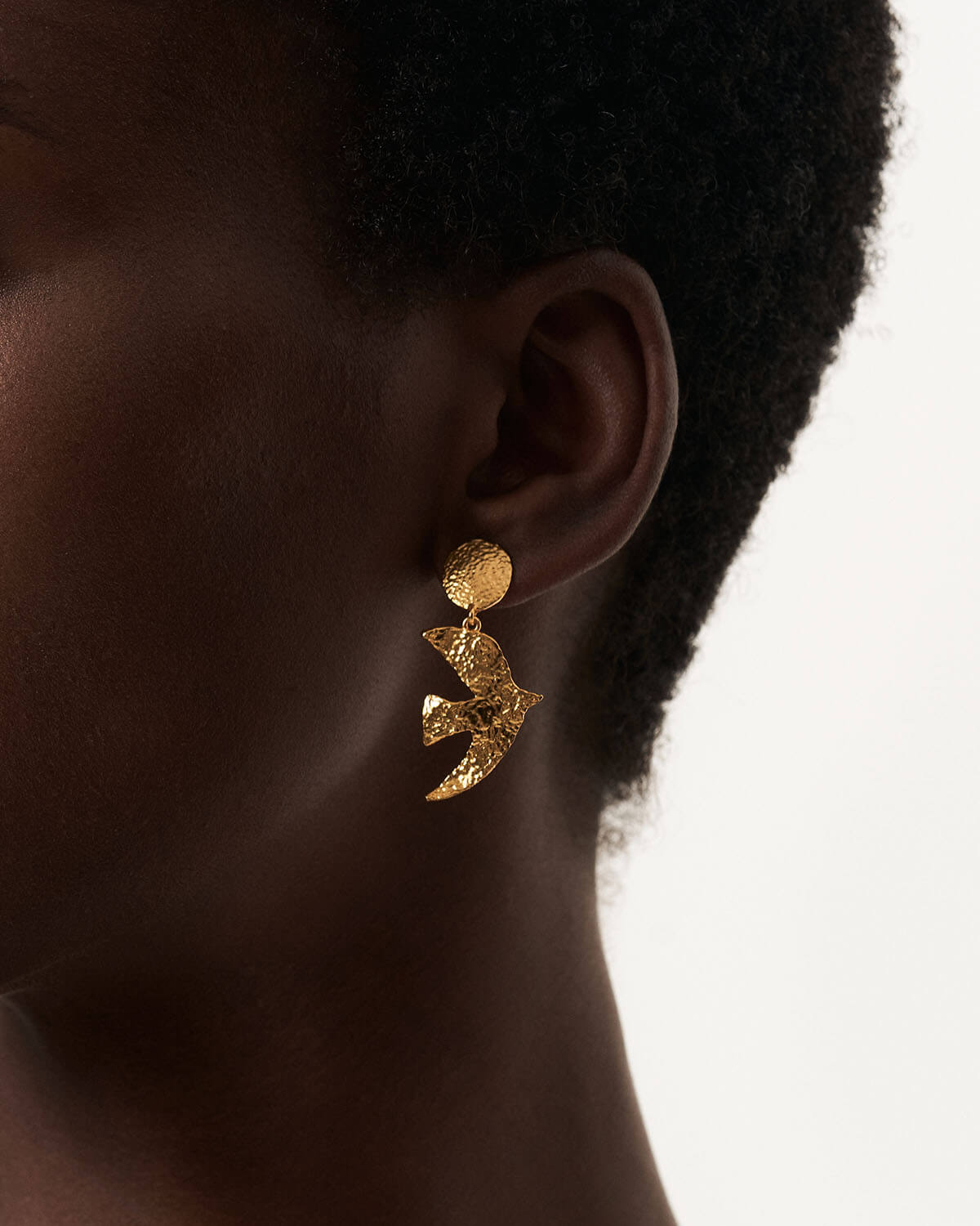 a close up of a person wearing a pair of earrings