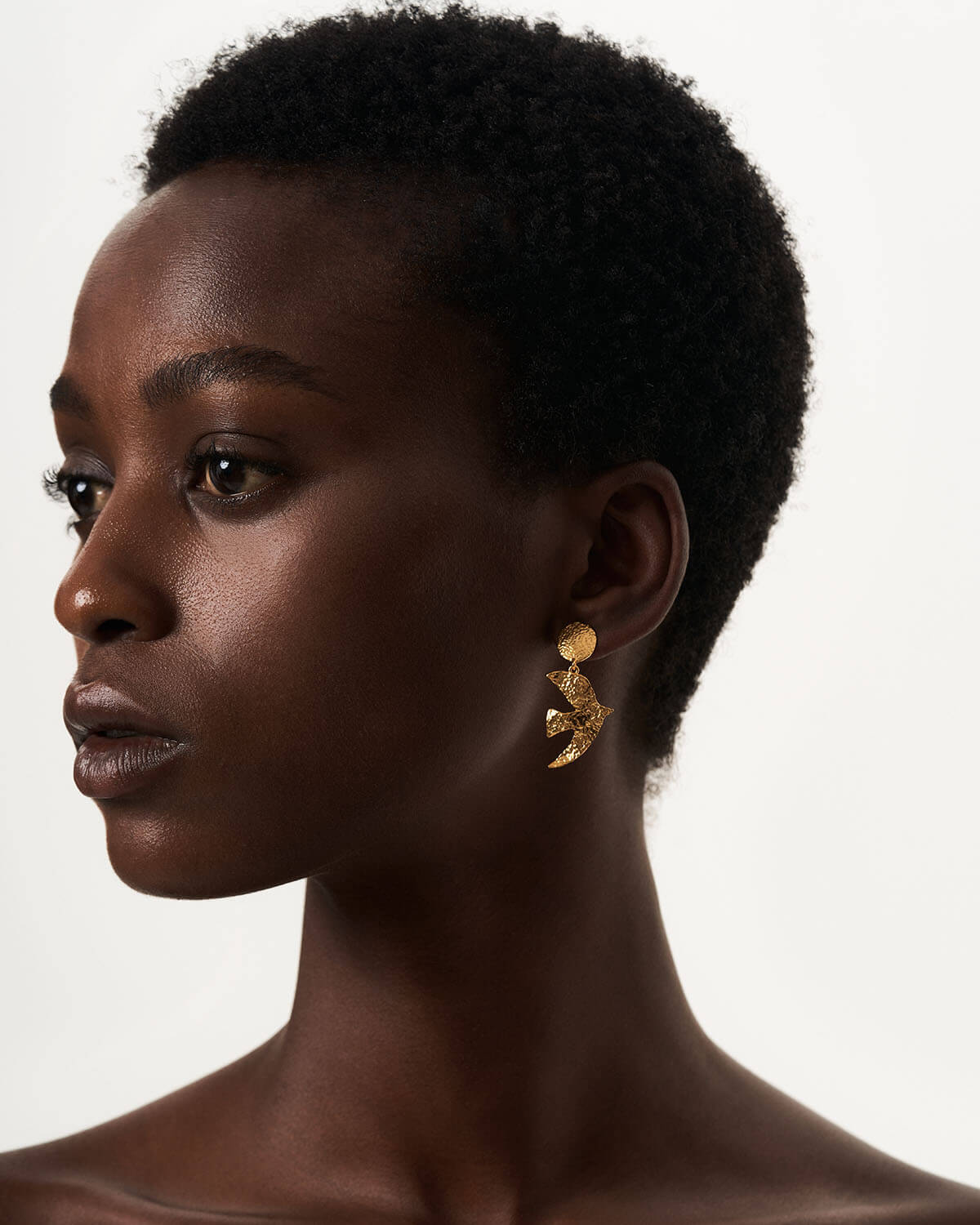 a close up of a person wearing a pair of earrings