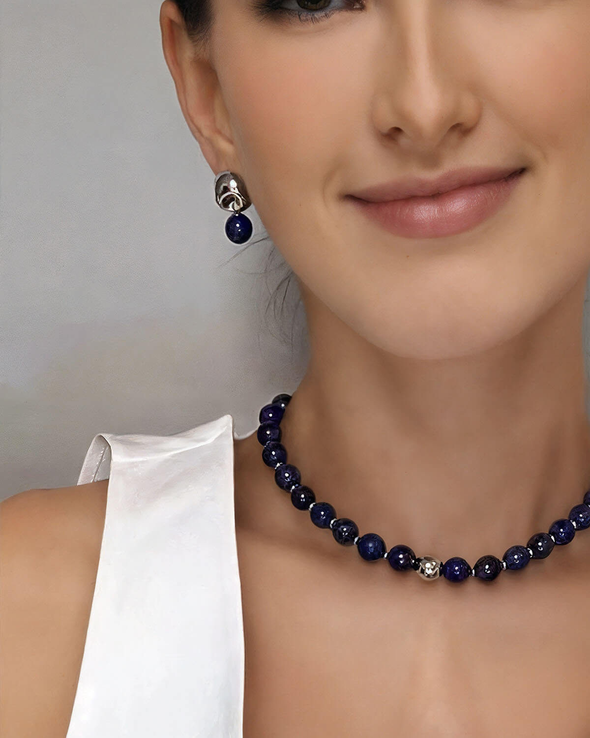 a woman wearing a blue necklace and earrings