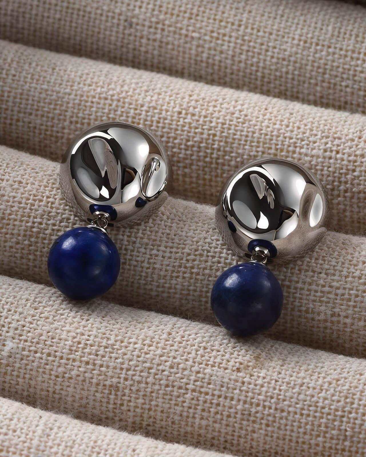 a pair of earrings with a blue bead