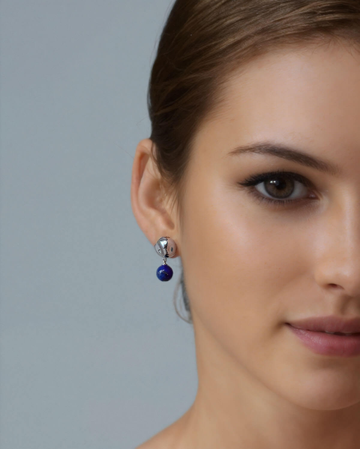 a close up of a person wearing a necklace and earrings