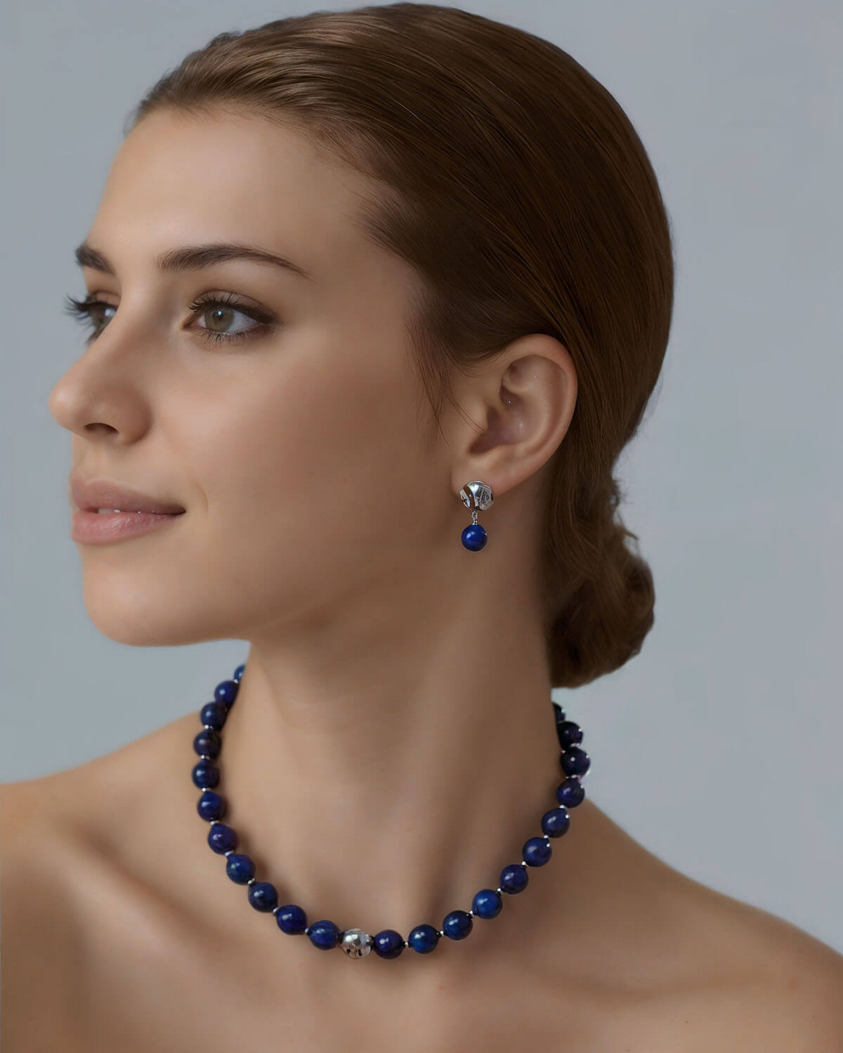 a woman wearing a blue necklace and earrings