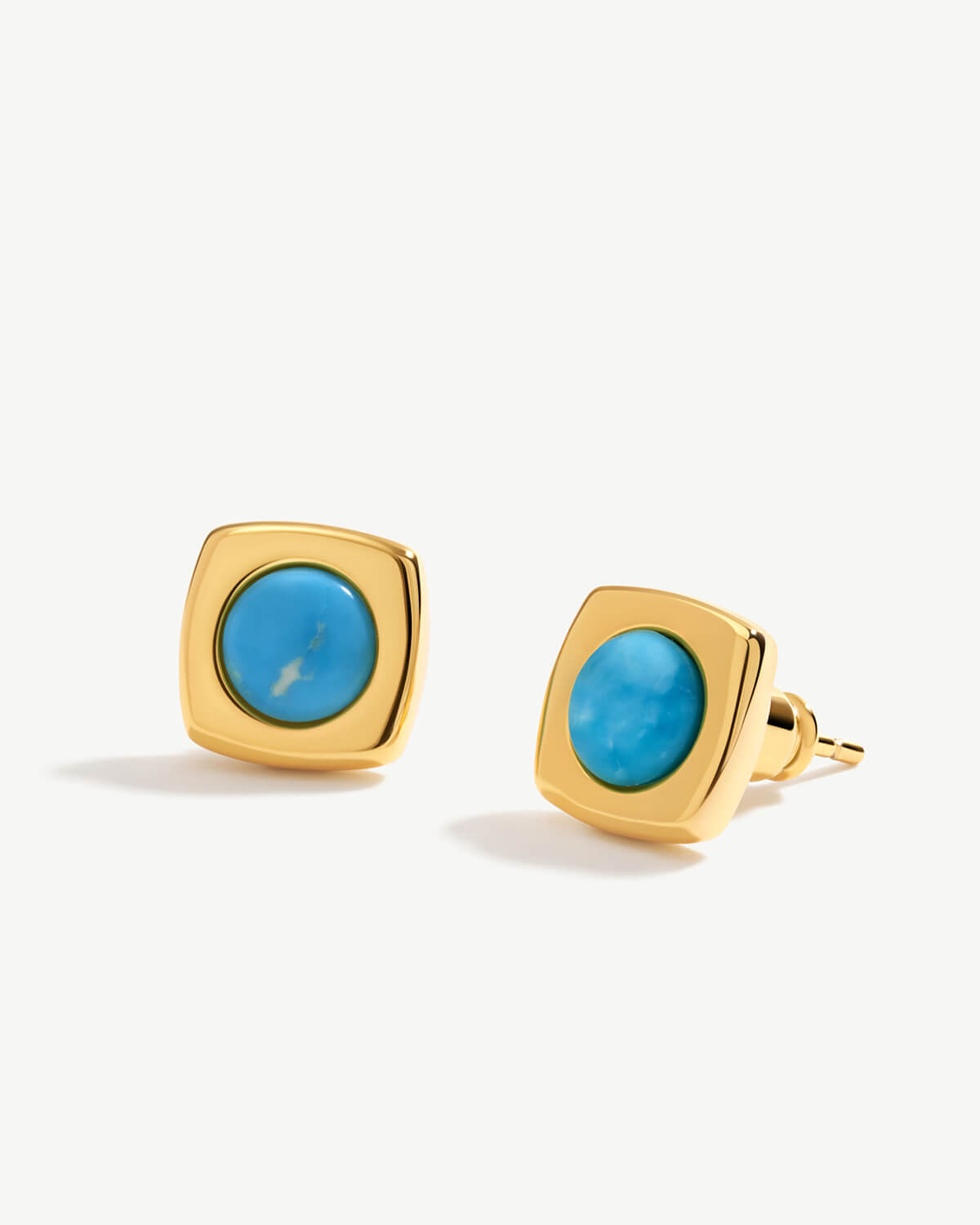 a pair of gold and turquoise stone earrings