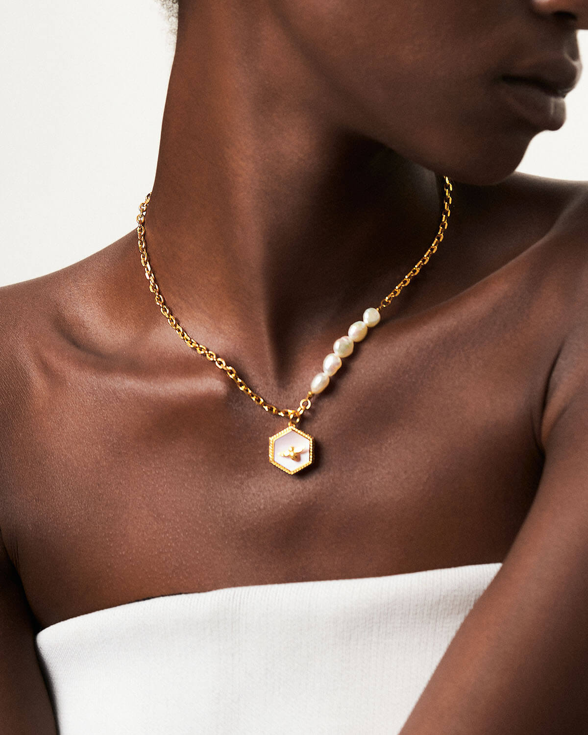 a woman wearing a necklace with a hexagon pendant