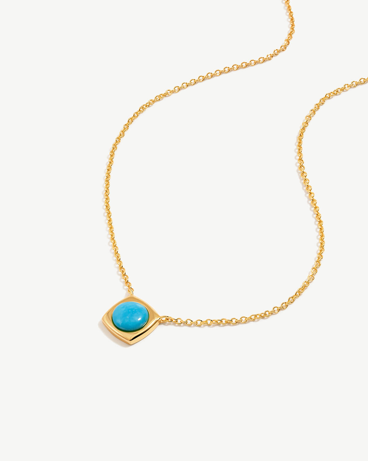 a gold necklace with a turquoise stone on it