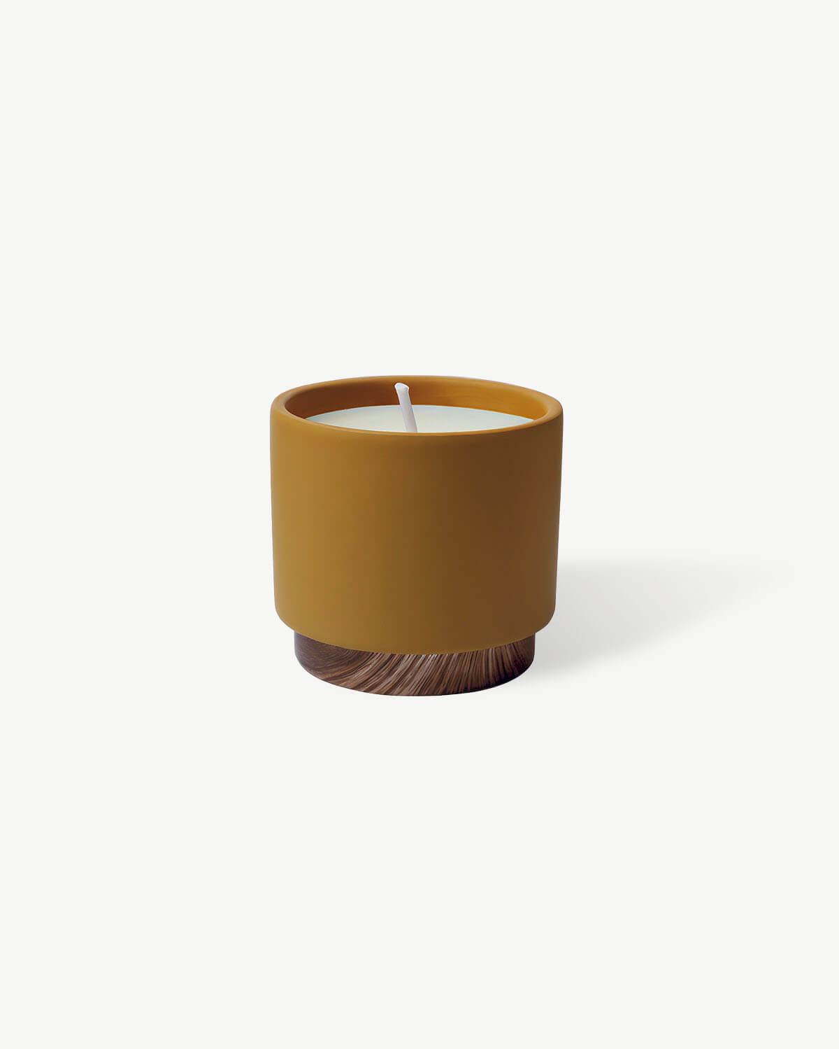 a yellow candle sitting on top of a wooden table