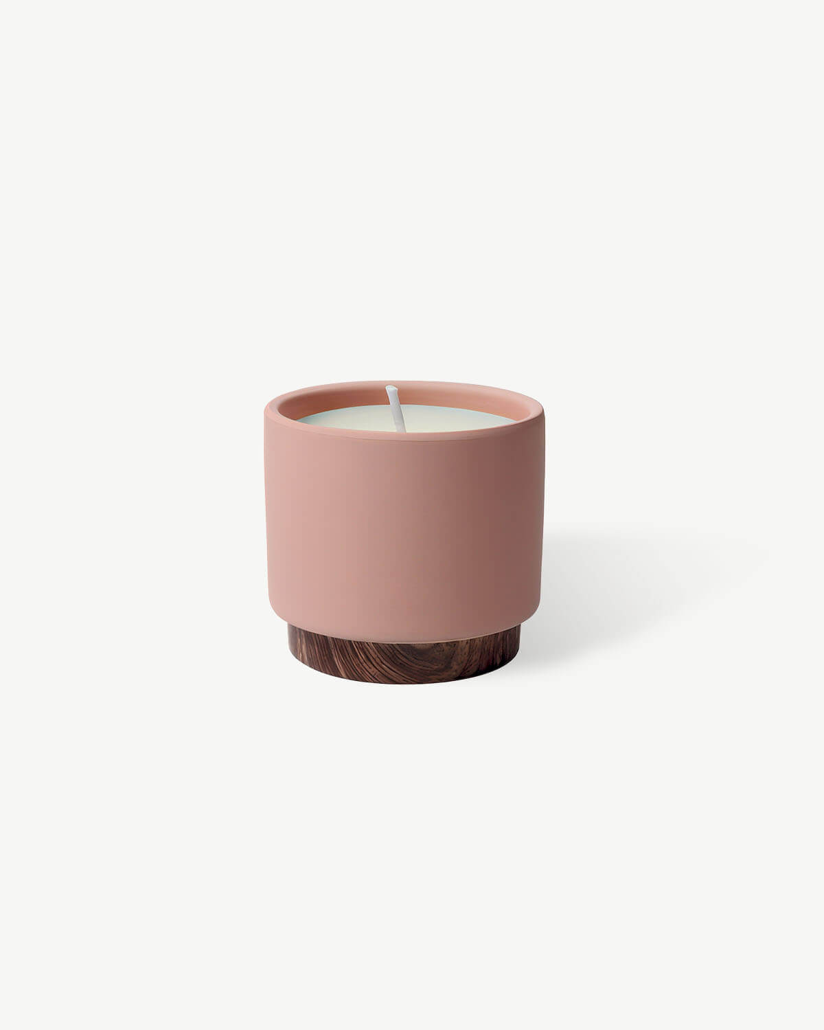 a small pink candle with a wooden base