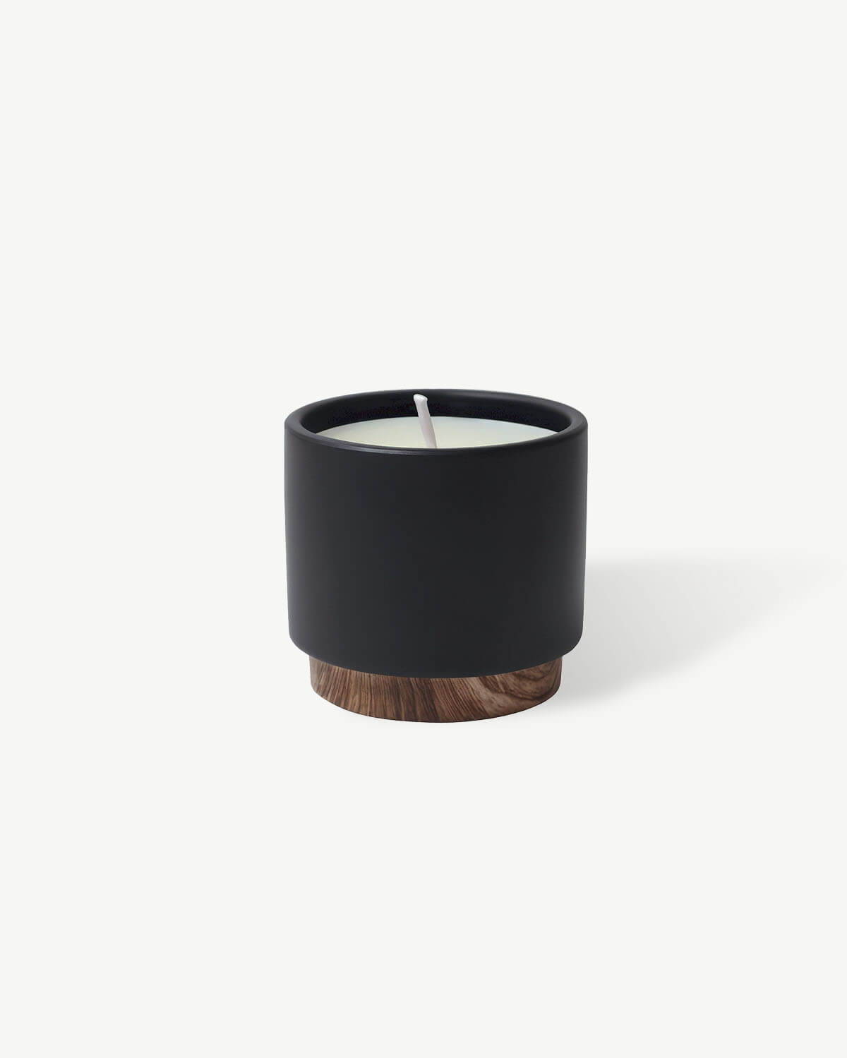 a black candle with a wooden base