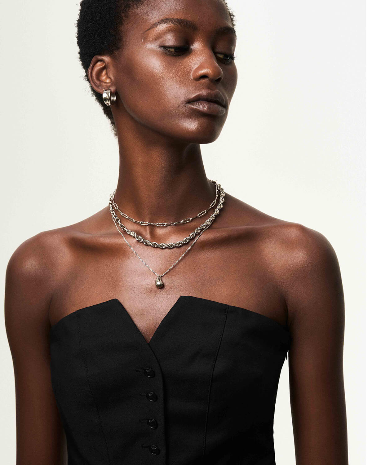 a woman wearing a black dress and a necklace