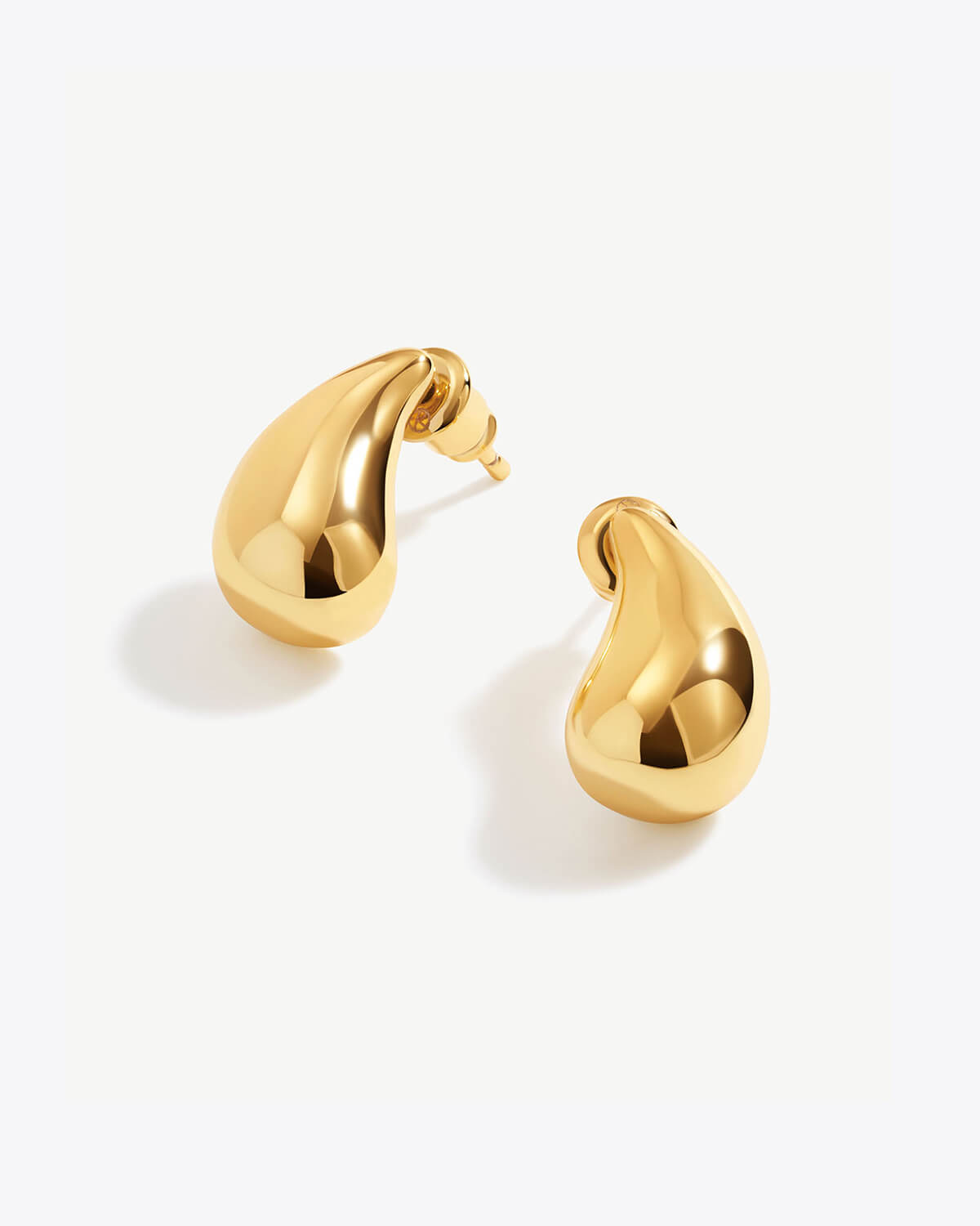 a pair of gold earrings on a white background