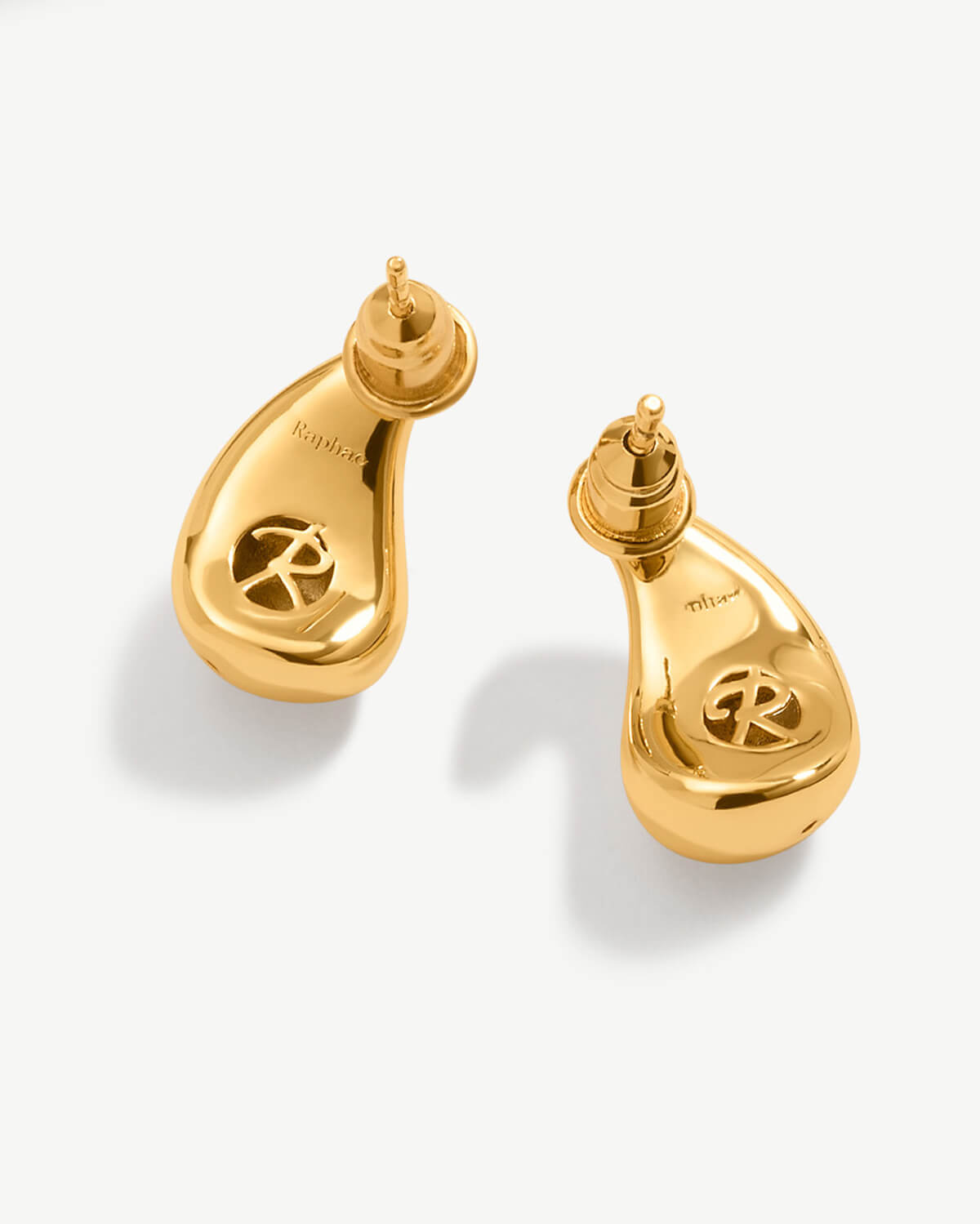 a pair of gold earrings on a white background