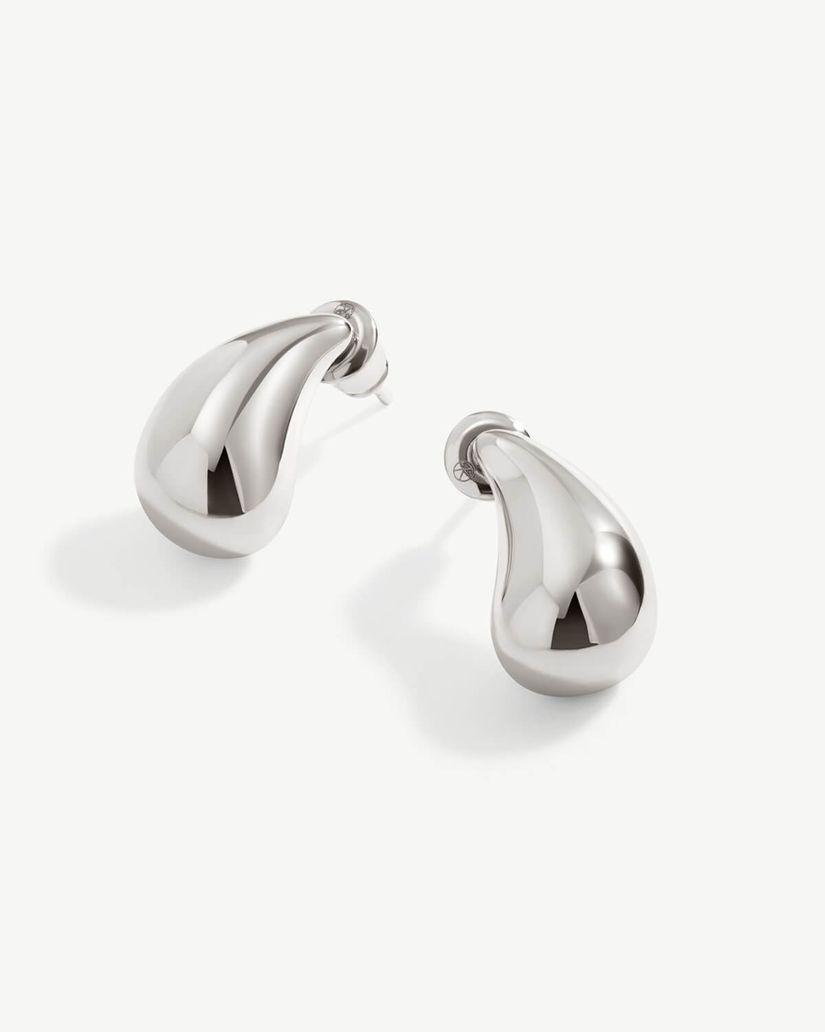 a pair of silver earrings on a white background